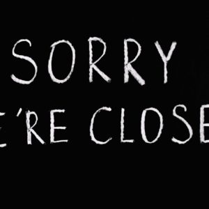 Hvit tekst på sort bakgrunn, som på en tavle: Sorry we're closed